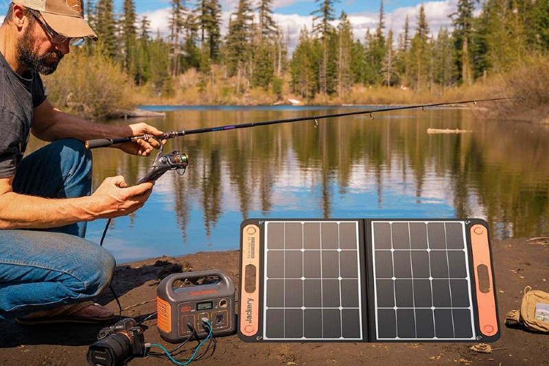 man fishing with portable Jackery solar panel and charger