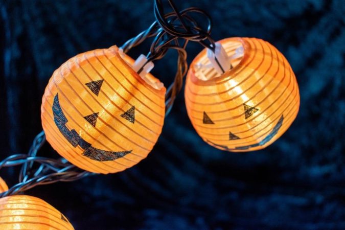 small paper pumpkin lanterns on string lights