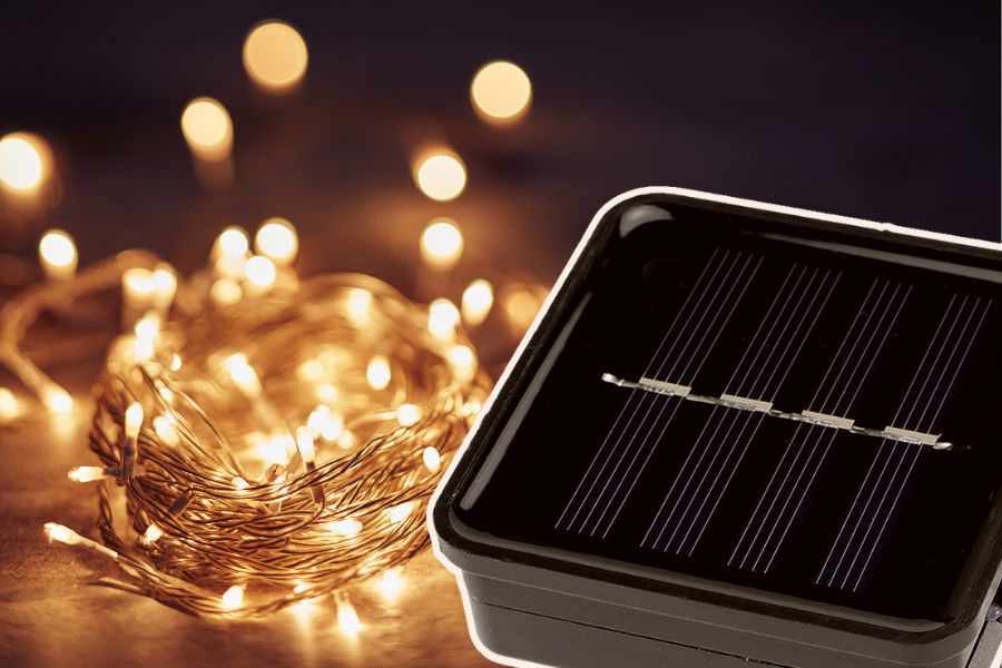 Solar fairy lights with solar panel on wooden surface