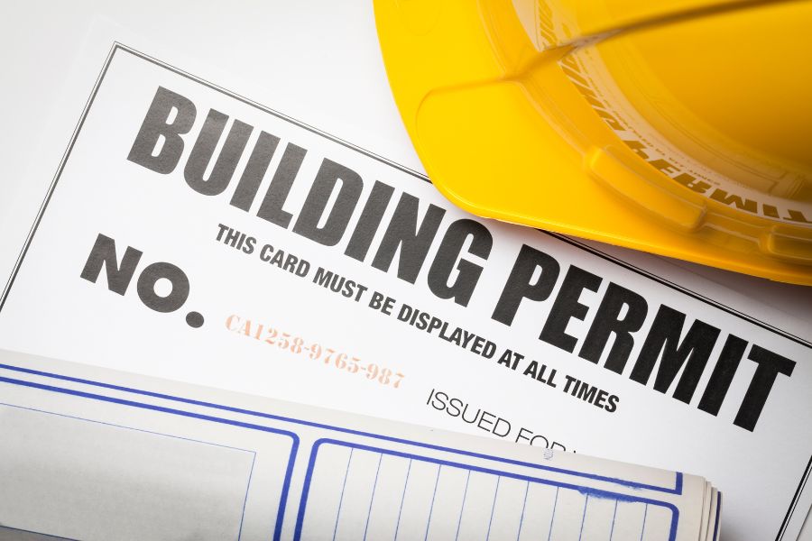 Building permit with hardhat and blueprint