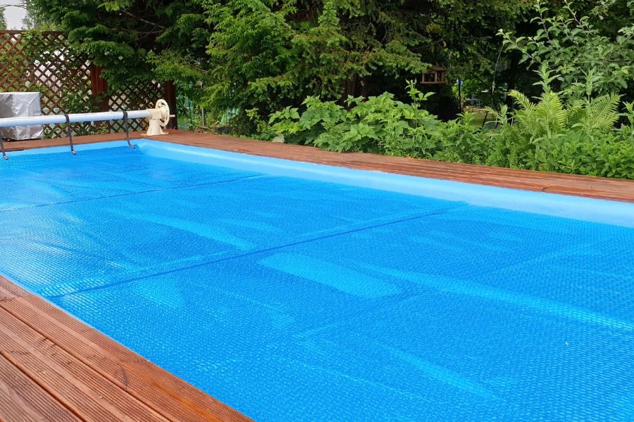 Outdoor swimming pool with blue solar cover